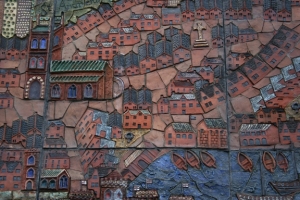 A detail: mediaeval streets and housing with small rowing boats lined up by the quay.