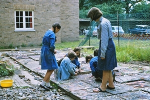 Here I am seen encouraging a group of small children as they arrange their pieces of ceramic and stone into the cement render. Only the youngest children worked in class. All the older girls worked on the mural on a voluntary basis in their own time. - click to enlarge Here I am seen encouraging a group of small children as they arrange their pieces of ceramic and stone into the cement render. Only the youngest children worked in class. All the older girls worked on the mural on a voluntary basis in their own time.