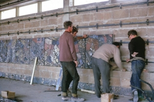 The first layer of panels goes up on the wall. Metal tracks had been screwed to the wall ready to receive fixing pieces which had been installed in the back of the concrete blocks. - click to enlarge The first layer of panels goes up on the wall. Metal tracks had been screwed to the wall ready to receive fixing pieces which had been installed in the back of the concrete blocks.